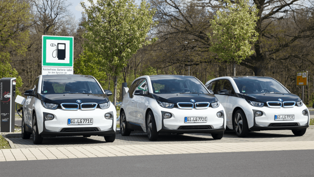 3 bmw cars lined up in EV charger parking spaces